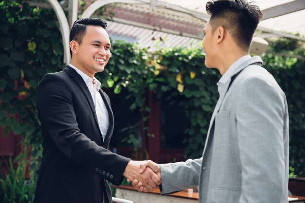 Dois jovens felizes, apertando as mãos