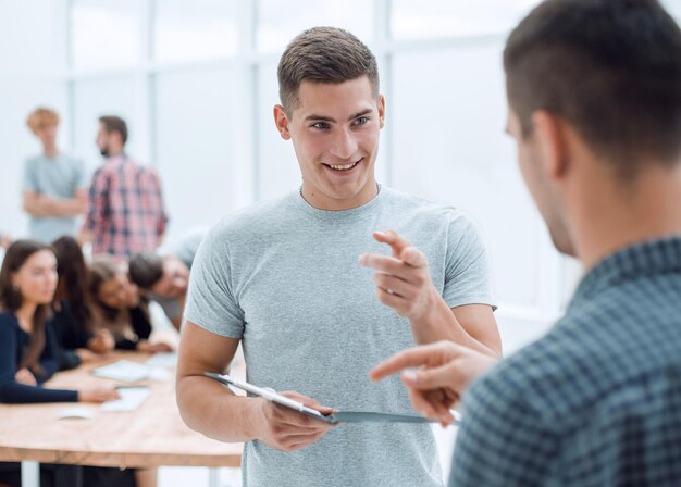 Dois jovens funcionários discutindo um documento comercial