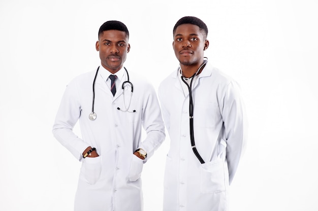 Dois jovens médicos africanos em um branco isolado com um estetoscópio