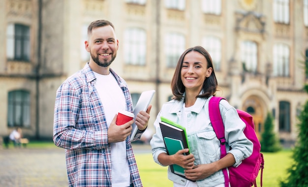 Dois jovens melhores amigos da universidade com roupas casuais e mochila conversando no campus e rindo