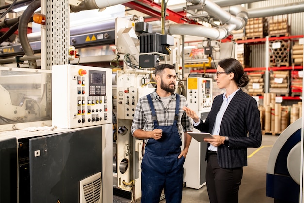 Dois jovens parceiros de negócios discutindo métodos de trabalho de produção industrial ou processamento de matérias-primas