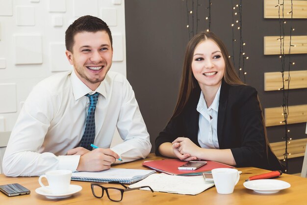 Dois jovens rindo sentados à mesa