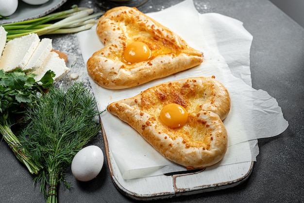 Dois khachapuri em forma de jantar de coração em um restaurante georgiano para dois no Dia dos Namorados