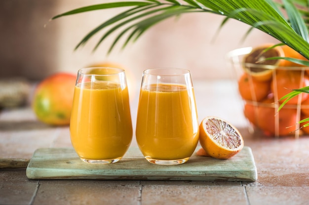 Dois lassi de manga ou leite kesar em copos Bebida fria ayurvédica saudável indiana com lassi de frescor de manga feito de iogurte água especiarias frutas e gelo