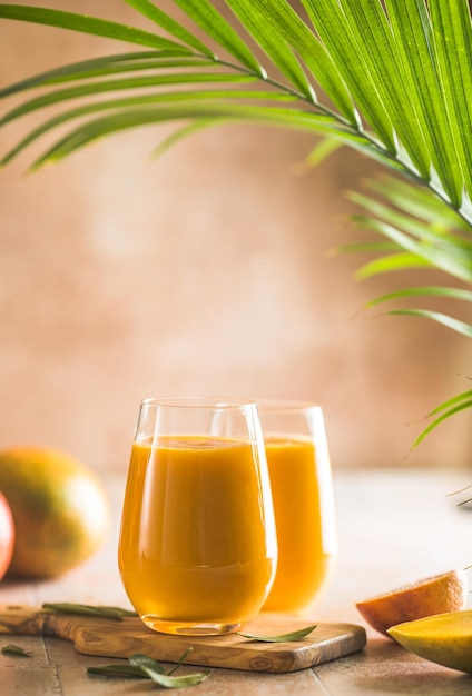 Dois lassi de manga ou leite kesar em copos Bebida fria ayurvédica saudável indiana com lassi de frescor de manga feito de iogurte água especiarias frutas e gelo