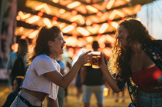 Dois lindos amigos bebendo cerveja e se divertindo em um festival de música