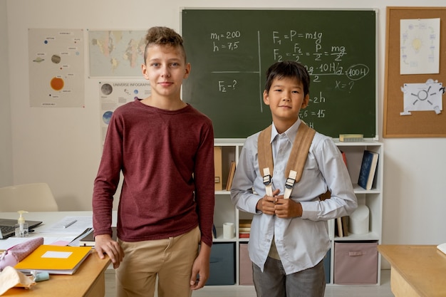 Dois lindos colegiais em roupas casuais olhando para você