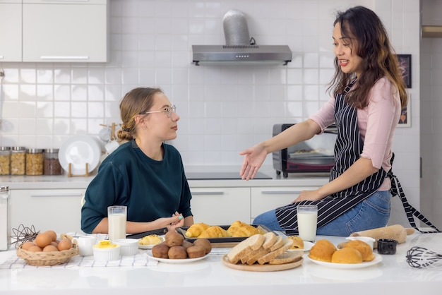 Dois lindos e felizes, uma linda padeiro fazendo doces As mulheres se divertiram em uma aula de panificação e usam as mãos para bater a massa na cozinha para fazer bolos.