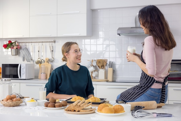 Dois lindos e felizes, uma linda padeiro fazendo doces As mulheres se divertiram em uma aula de panificação e usam as mãos para bater a massa na cozinha para fazer bolos.