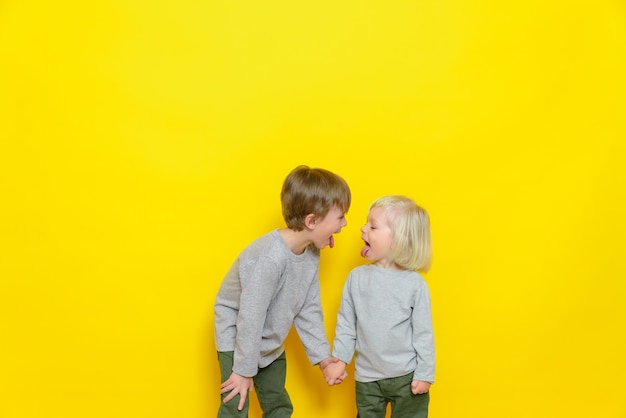 Dois lindos meninos mostram-se línguas e se divertem