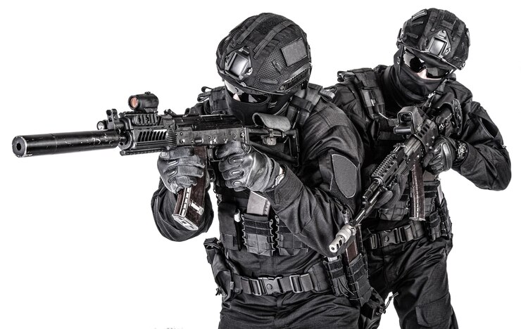 Foto dois lutadores da swat, membros do grupo tático de operações especiais da polícia em uniforme preto e capacete, armados com rifles de assalto avançando um atrás de outro tiro em estúdio isolado no fundo branco
