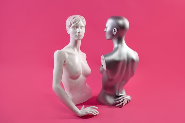 Dois manequins em uma parede rosa. moda e design.