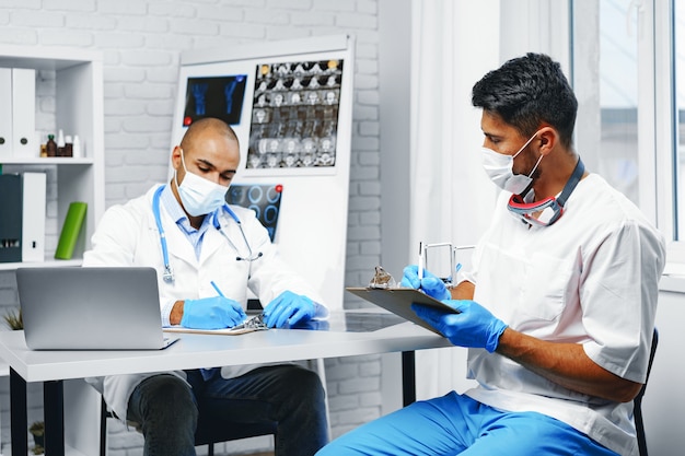 Dois médicos discutindo seu trabalho no gabinete do hospital