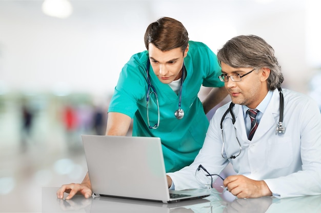 Dois médicos do sexo masculino usando laptop