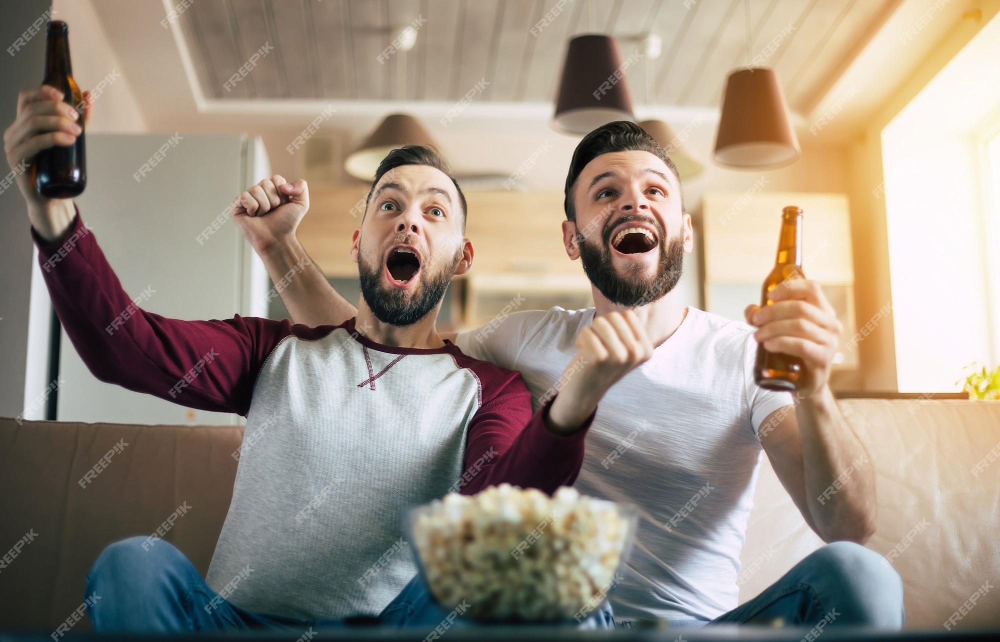 Conceitual assistir jogo de futebol no sofá na televisão com garrafas de  cerveja e tigela de pipoca em amigos apreciando jogo de futebol TV fotos,  imagens de © TheVisualsYouNeed #193389504