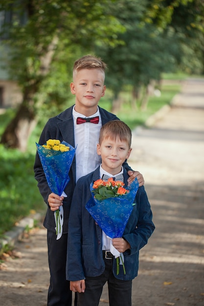 Dois meninos adoráveis com um lindo buquê de flores na natureza