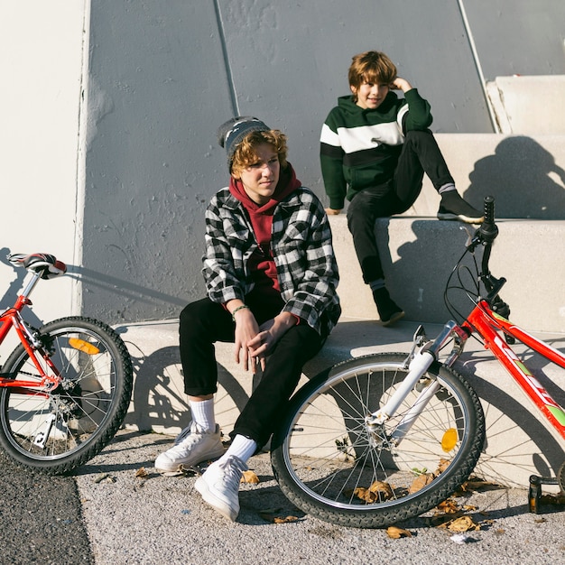 Foto dois meninos ao ar livre com suas bicicletas