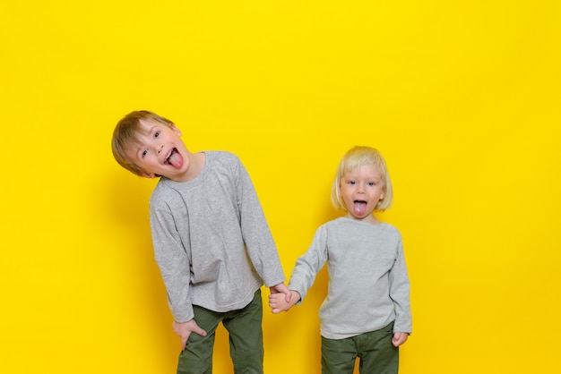 Dois meninos bonitos se divertem e mostram a língua.