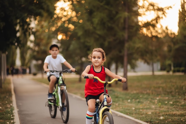 Dois meninos e meninas ciclistas andando de bicicleta e gostam de se divertir criança ao ar livre atividade de verão