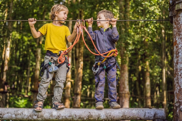 Dois meninos em um parque de cordas Recreação física ativa da criança ao ar livre no parque Treinamento para crianças