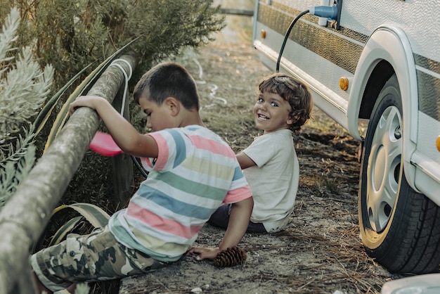 Dois meninos em uma caravana brincando na natureza