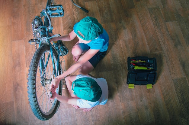 Dois meninos reparam uma bicicleta