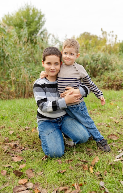 Dois meninos se divertindo juntos ao ar livre. Família feliz. Irmãos se abraçando