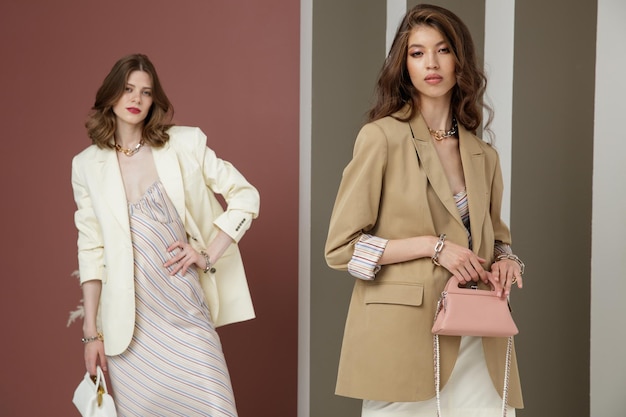 Dois modelos de moda em creme branco e marrom areia parece Jaqueta blazer saia vestido longo bolsa
