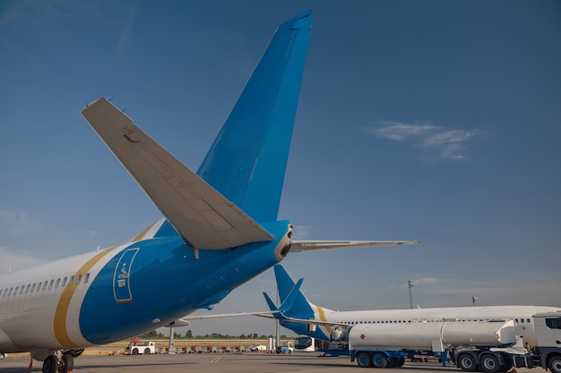 Dois modernos aviões grandes no aeroporto com céu azul ao fundo. Avião, conceito de transporte