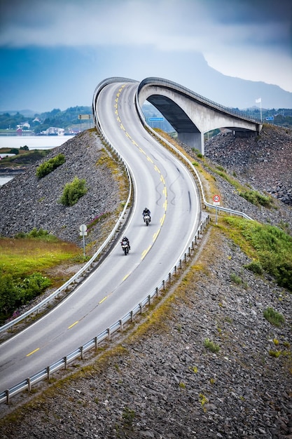 Dois motociclistas em motocicletas. Atlantic Ocean Road ou Atlantic Road (Atlanterhavsveien) foi premiada com o título de "Construção Norueguesa do Século".