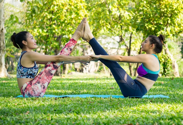 Dois, mulher, fazendo ioga, pose, em, ao ar livre, ioga, prática, treinamento, conceito