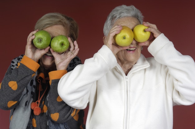 Dois, mulher sênior, tocando, com, frutas