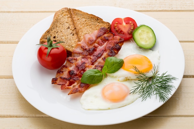 Dois ovos fritos e bacon no café da manhã saudável. foco seletivo