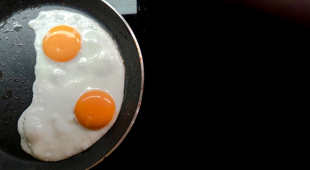 Dois ovos fritos em uma panela de teplon.