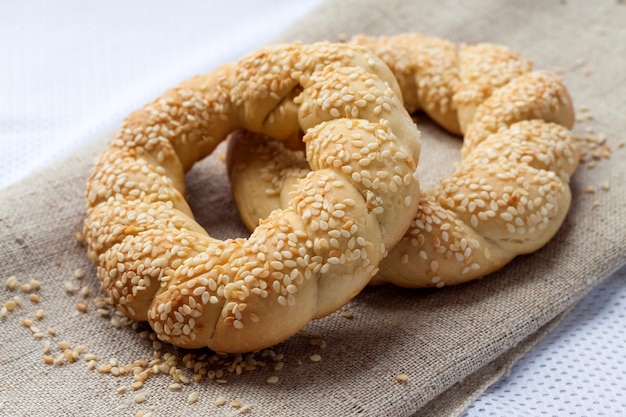 Dois pães caseiros com gergelim em uma tela cinza