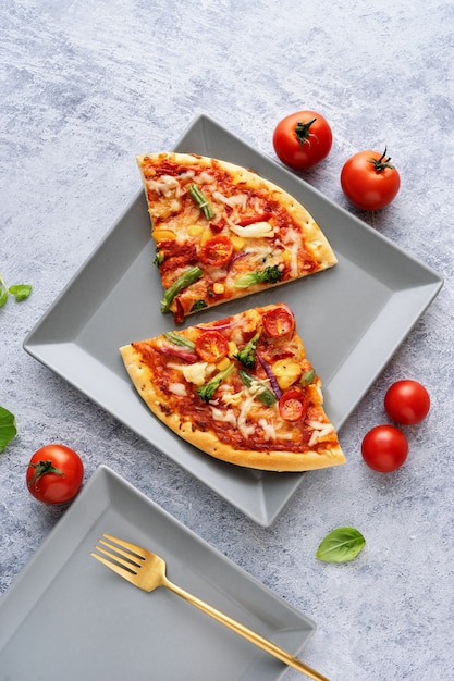 Dois pedaços de pizza vegetariana sobre fundo azul claro