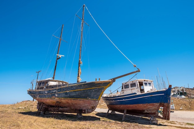 Dois pequenos barcos envelhecidos ficam no chão em Paros Grécia