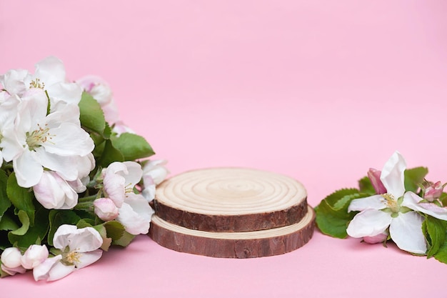 Dois pódios de madeira e flores brancas em uma maquete de fundo rosa