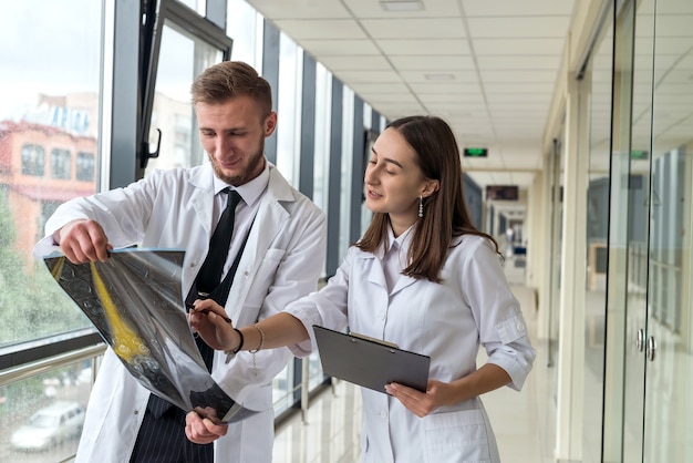 Dois profissionais de saúde observando a imagem de raio-x, ressonância magnética do paciente para diagnóstico e tratamento no hospital