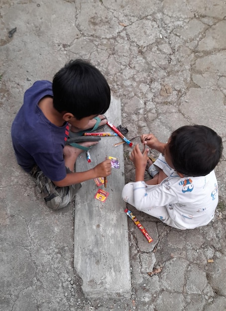 Dois rapazes estão a brincar com um bastão e um bastão.