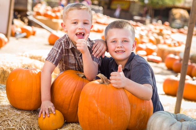 Dois rapazes no Pumpkin Patch com os polegares para cima