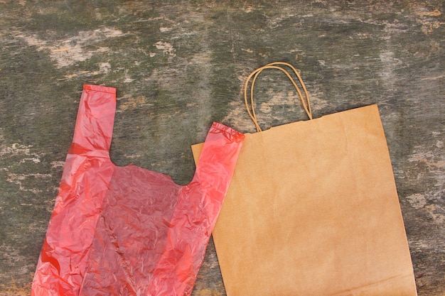 Dois sacos de papel e polietileno diferentes em um fundo de madeira velho. vista do topo. postura plana.