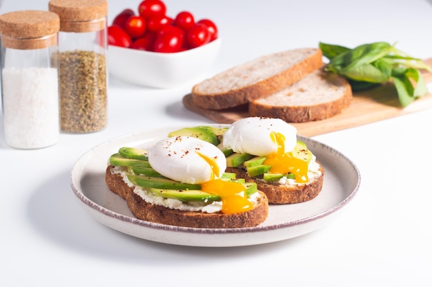 Foto dois sanduíches abertos de abacate com ovo. conceito de ceto e dieta. comida de torrada saudável no café da manhã.