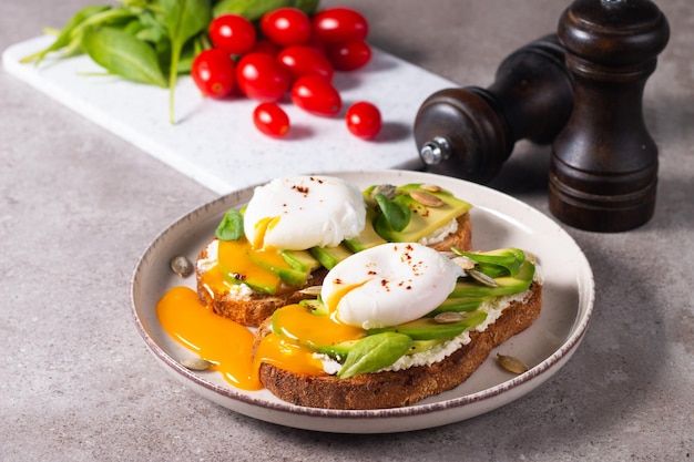 Dois sanduíches abertos de abacate com ovo. conceito de ceto e dieta. comida de torrada saudável no café da manhã.