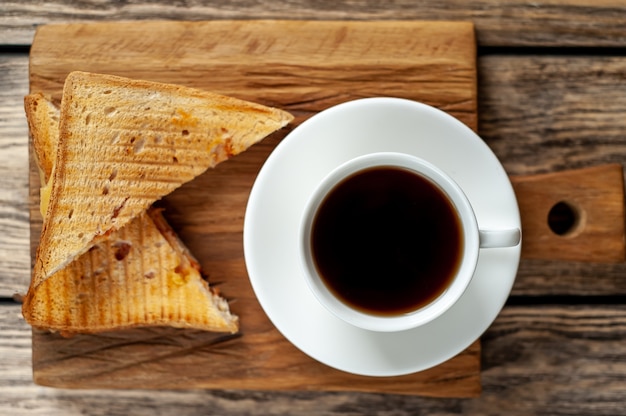 dois sanduíches e café em um fundo de madeira