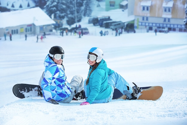 Dois snowboarders na pista de esqui em um resort nevado