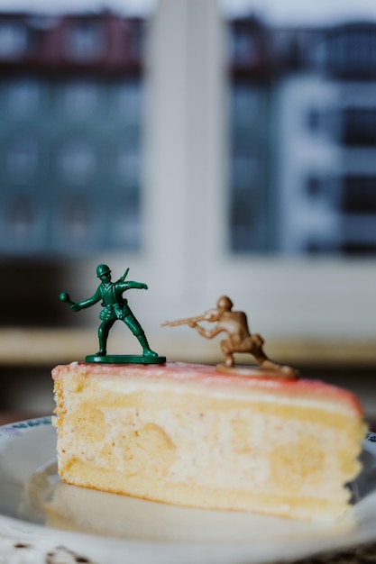 Dois soldados de brinquedo lutando no topo de um bolo sobre ter uma sobremesa ou não - bolo de close-up