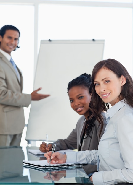 Foto dois, sorrindo, executivos, trabalhando, durante, um, apresentação, enquanto, escrita, em, um, caderno