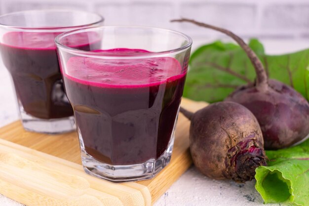 Dois suco de beterraba fresca bem em uma placa de madeira