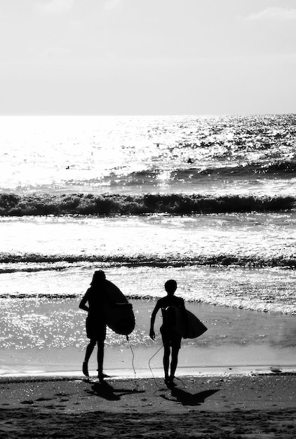 Dois surfistas desconhecidos vão para o mar